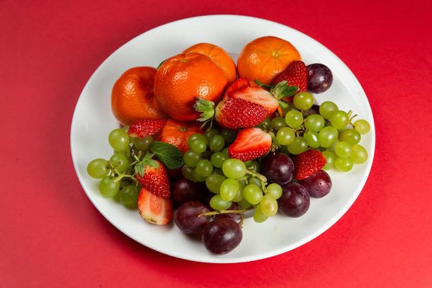 Фруктовая тарелка с сезонными ягодами и виноградом